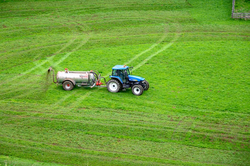 tractor in field pulling fertilizer tank